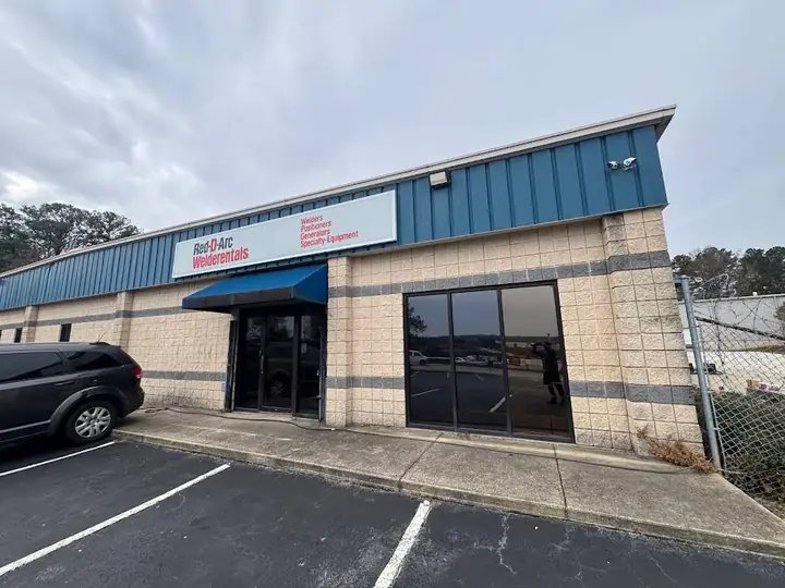 Clean commercial storefront, sidewalk, and parking area after exterior washing.