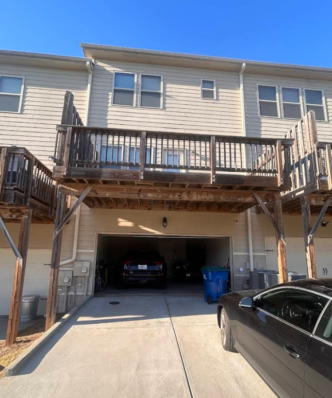 Weathered wood deck structure and railing on a multi-story residential building